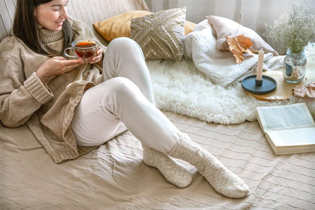 cozy-autumn-home-woman-knitted-sweater-with-cup-tea 居家擺設