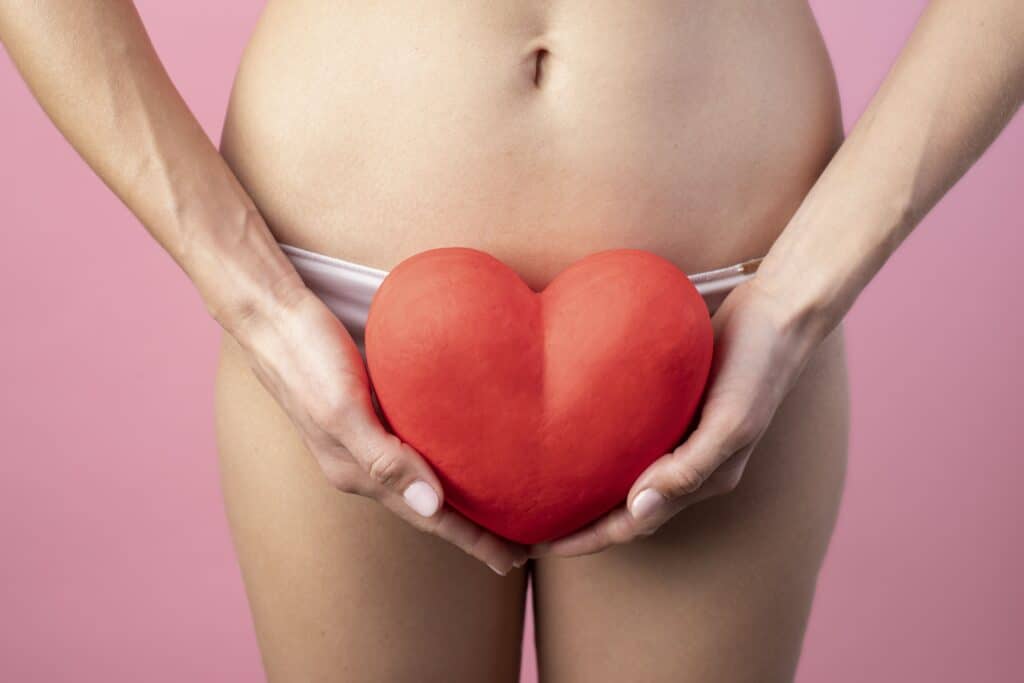 heart-shape-held-by-woman-near-her-reproductive-system